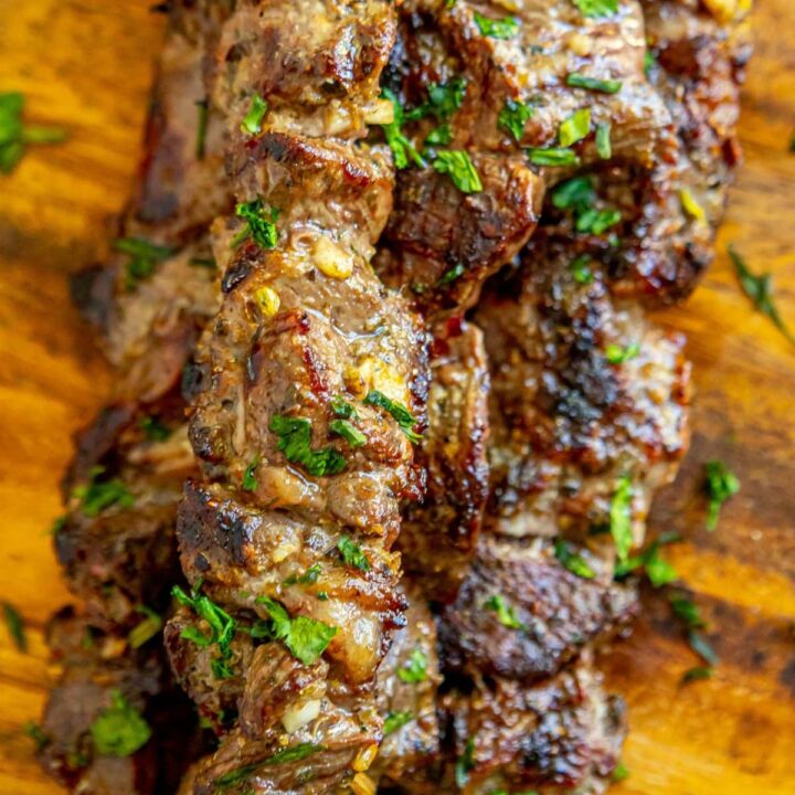 picture of lamb souvlaki on wooden cutting board with chopped cilantro on top