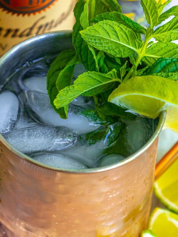 picture of a moscow mule in a copper cup with ice a lime wedge and mint