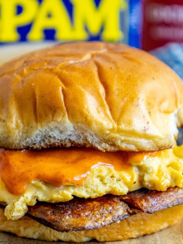 picture of fried spam and eggs on a sandwich with a spicy mayo sauce on it on a cutting board