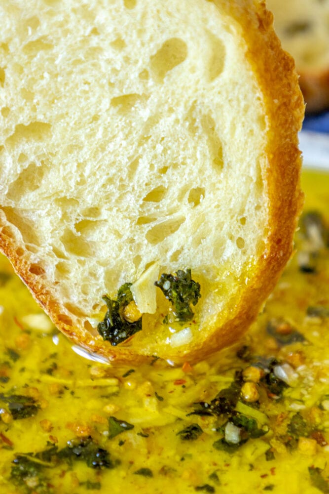 picture of a slice of bread dipped in olive oil bread dip 