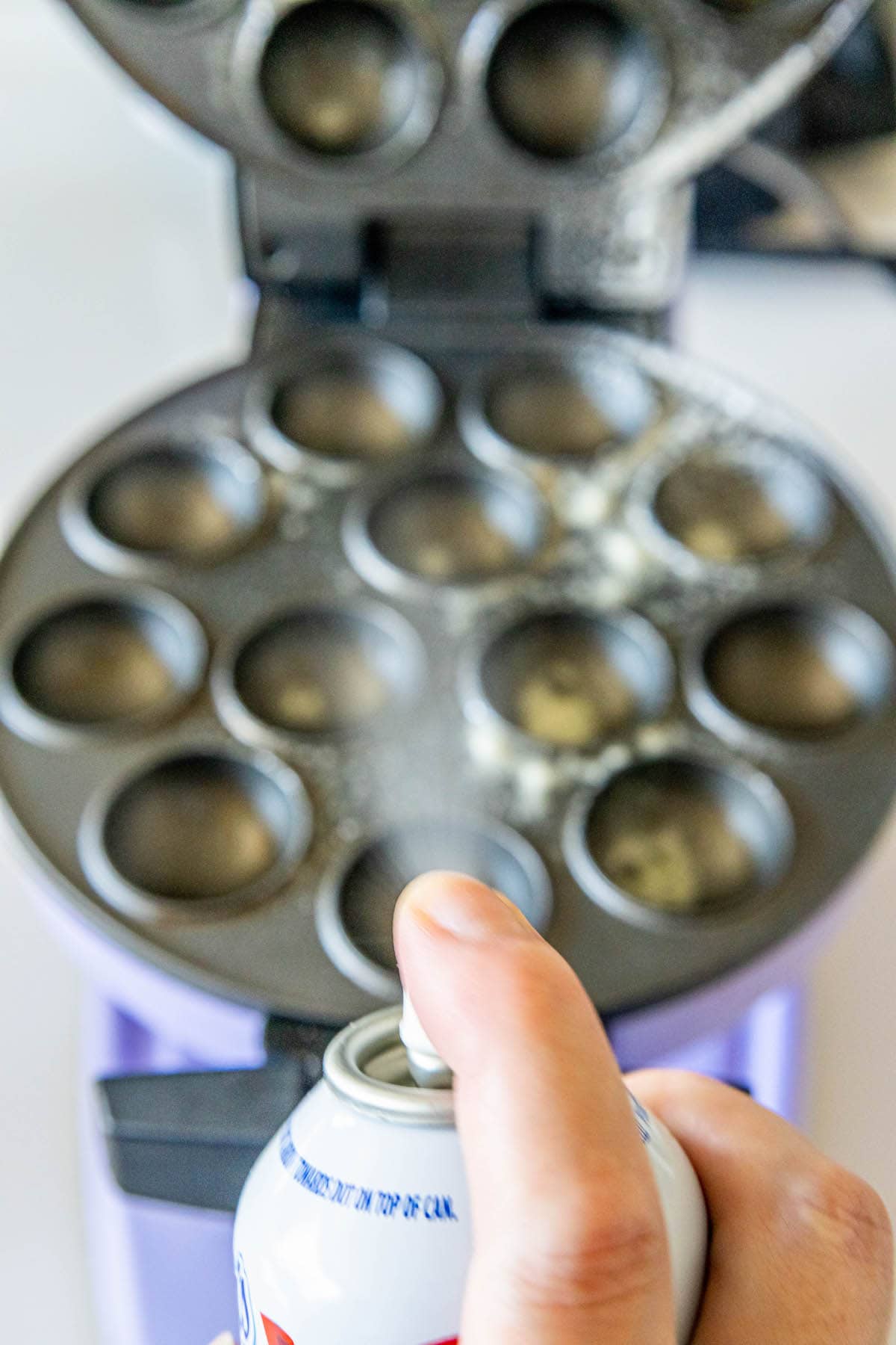 picture of nonstick spray being sprayed onto cake pop pan