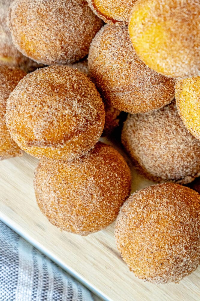 picture of donut holes rubbed in cinnamon sugar stacked on a cutting board