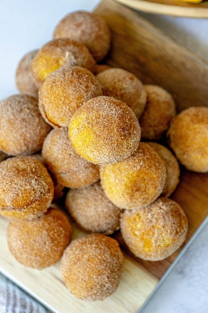 picture of donut holes rubbed in cinnamon sugar stacked on a cutting board