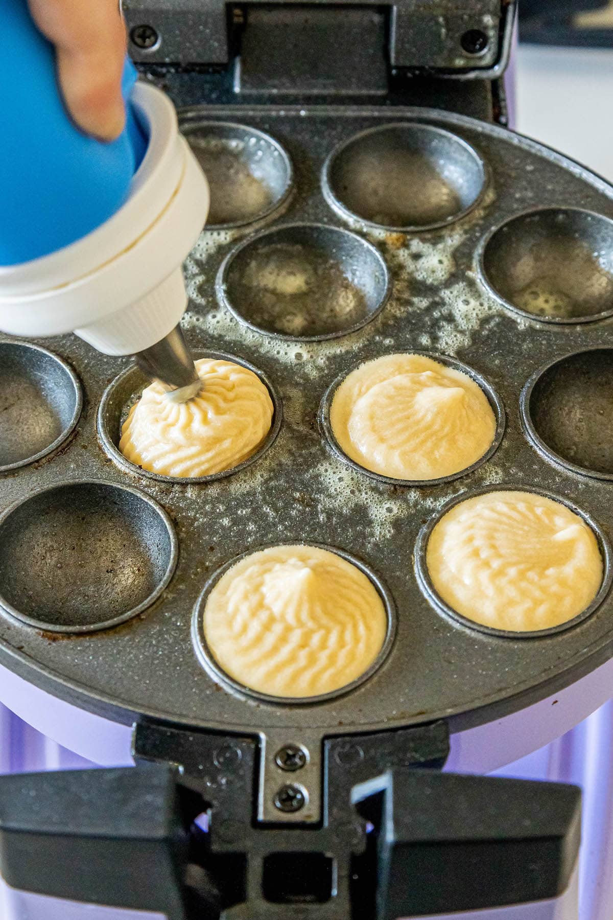 picture of donut holes being piped into cake pop pan