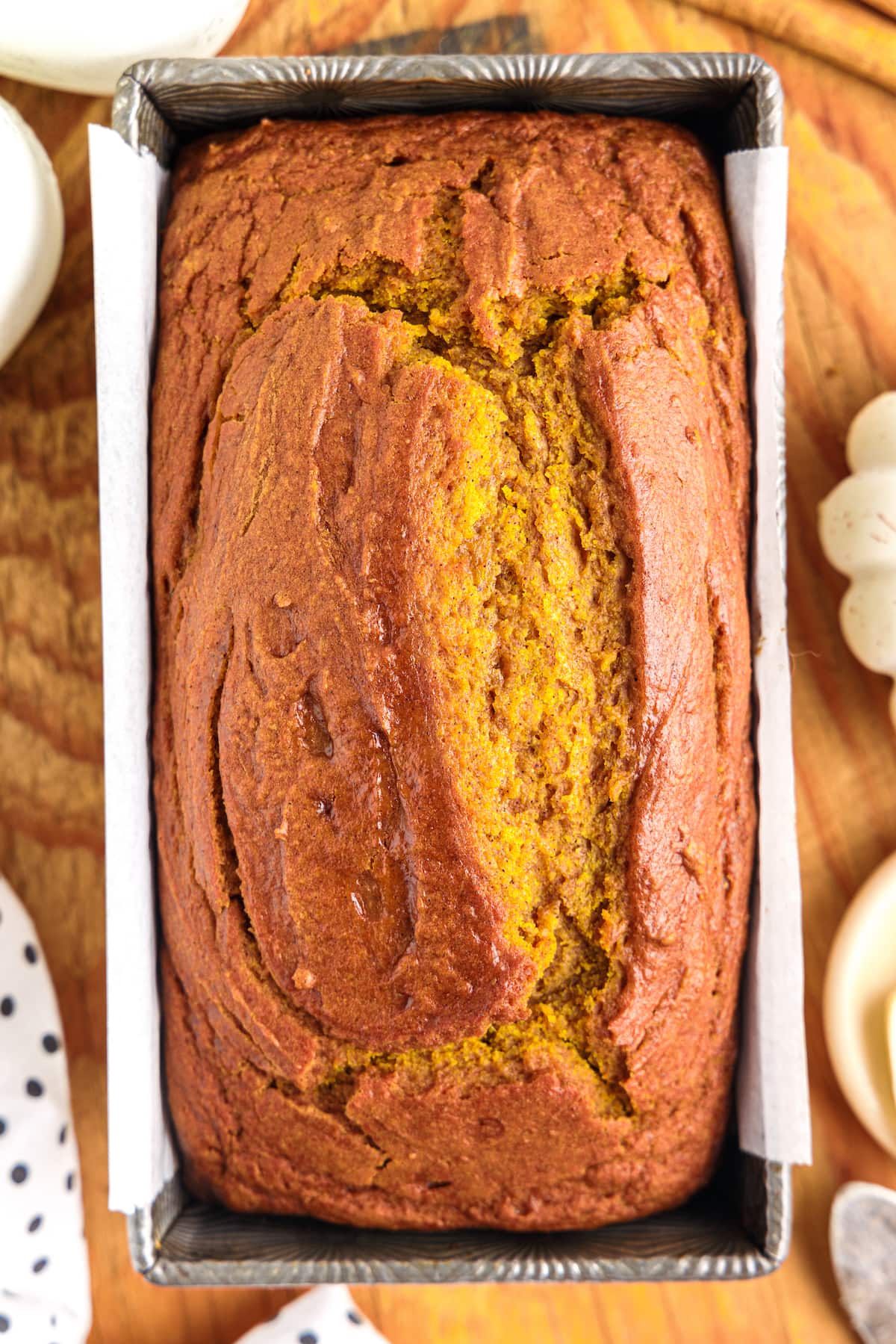 picture of pumpkin bread in a loaf pan on a cutting board