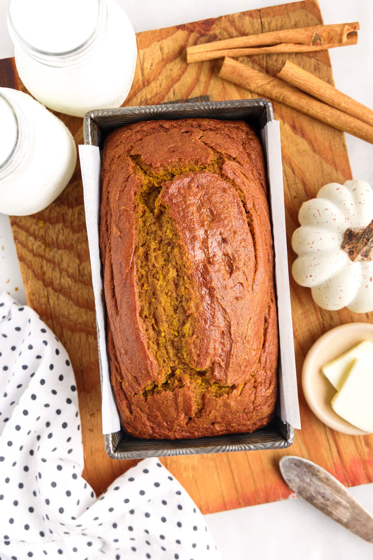picture of pumpkin bread in a loaf pan on a cutting board