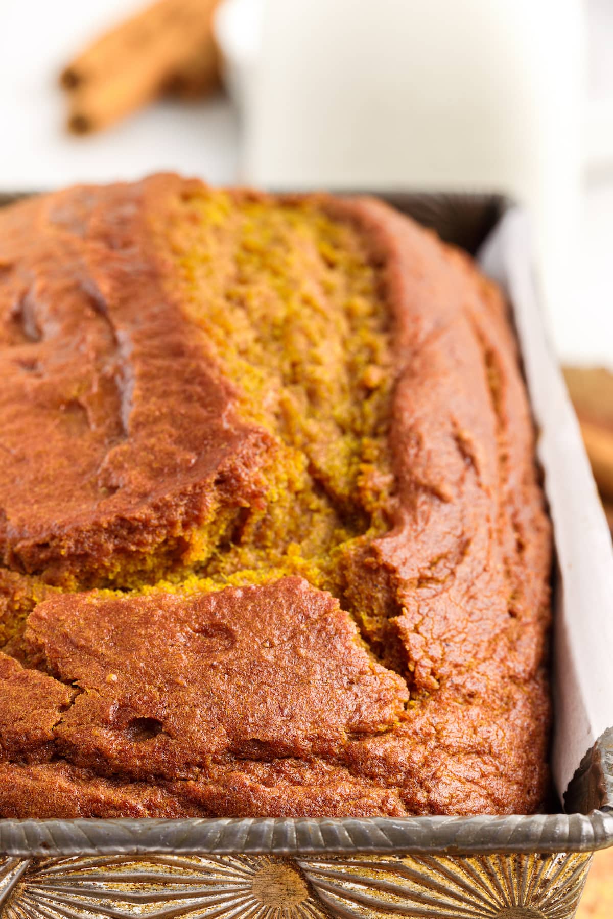 picture of pumpkin bread in a loaf pan on a cutting board