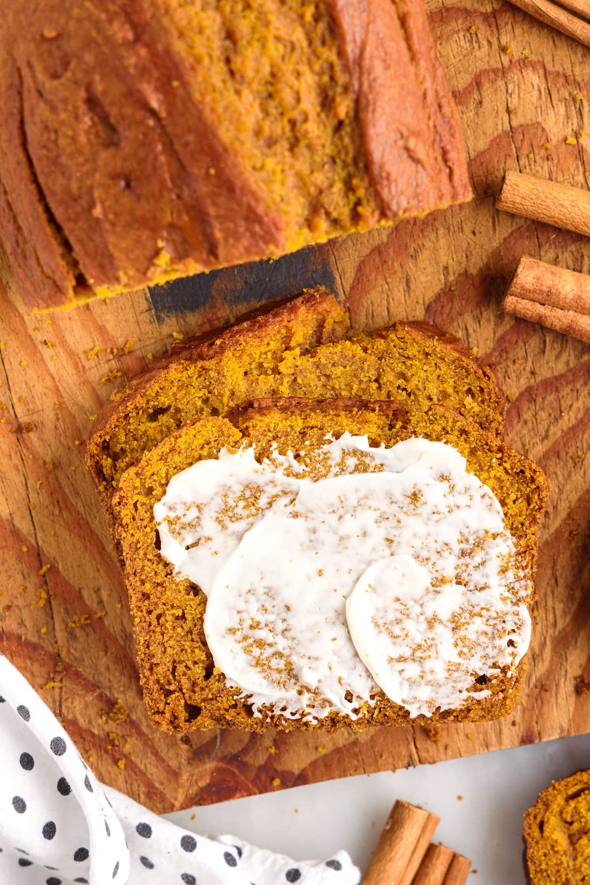 picture of pumpkin bread  sliced with butter slathered on top 