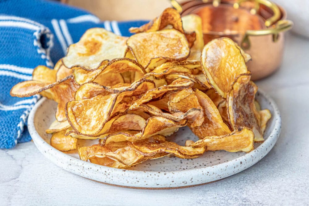 picture of air fried potato chips piled on a plate and seasoned with garlic salt