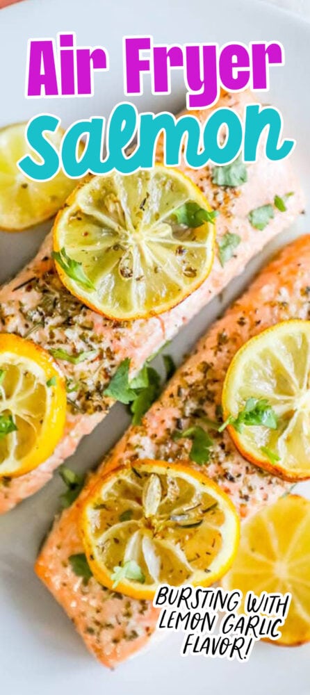 salmon filets with lemon slices, garlic and herbs on top on a white plate