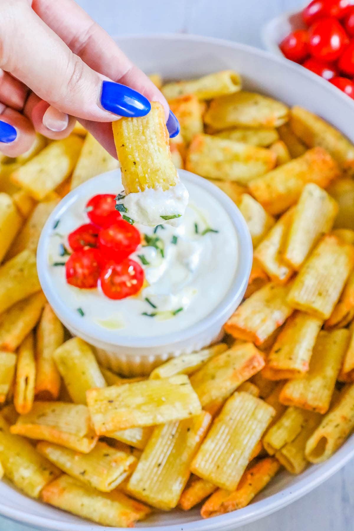 picture of pasta chips in a white bowl with whipped feta dip in a cup 
