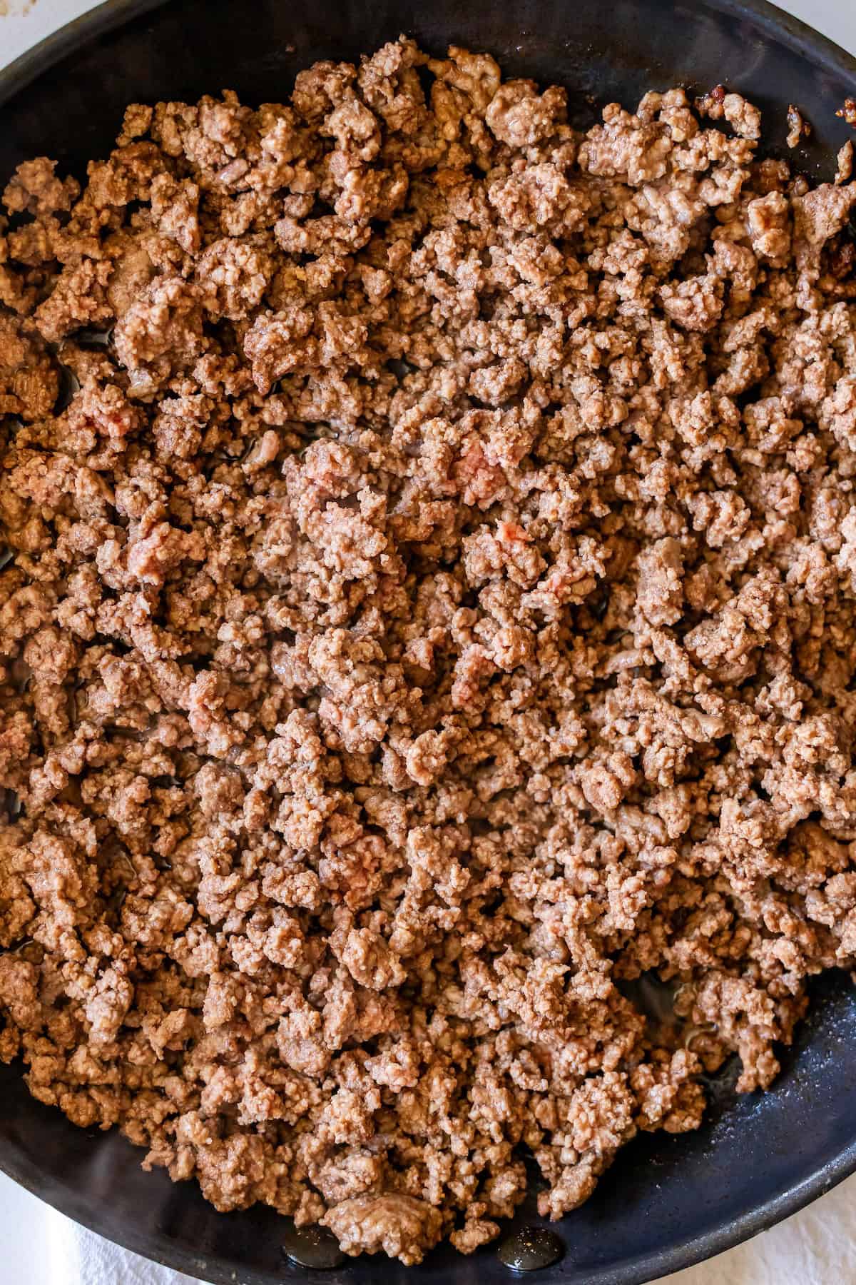 Cooked ground beef in a black skillet, browned and crumbled into small pieces—perfect for creating The Best Taco Skillet.