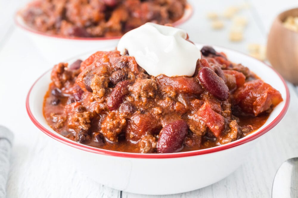 picture of chili in a bowl with sour cream on top 