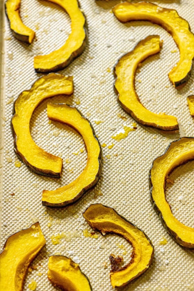 picture of acorn squash slices on a baking sheet on a table