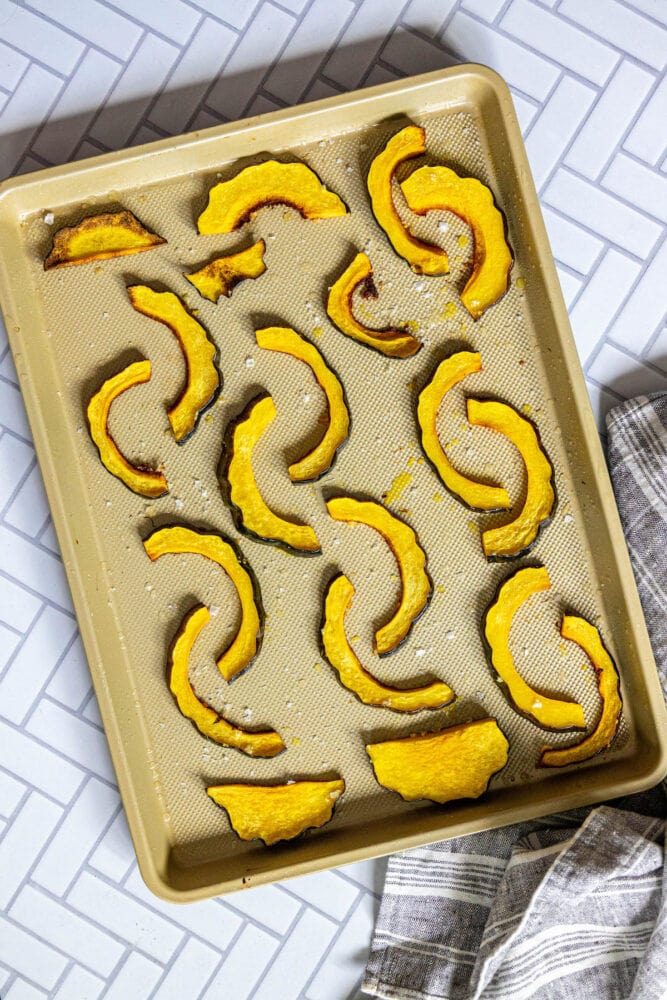 picture of acorn squash slices on a baking sheet on a table