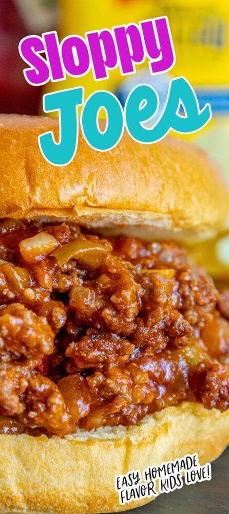 sloppy joe in a bun with lots of sauce on a table