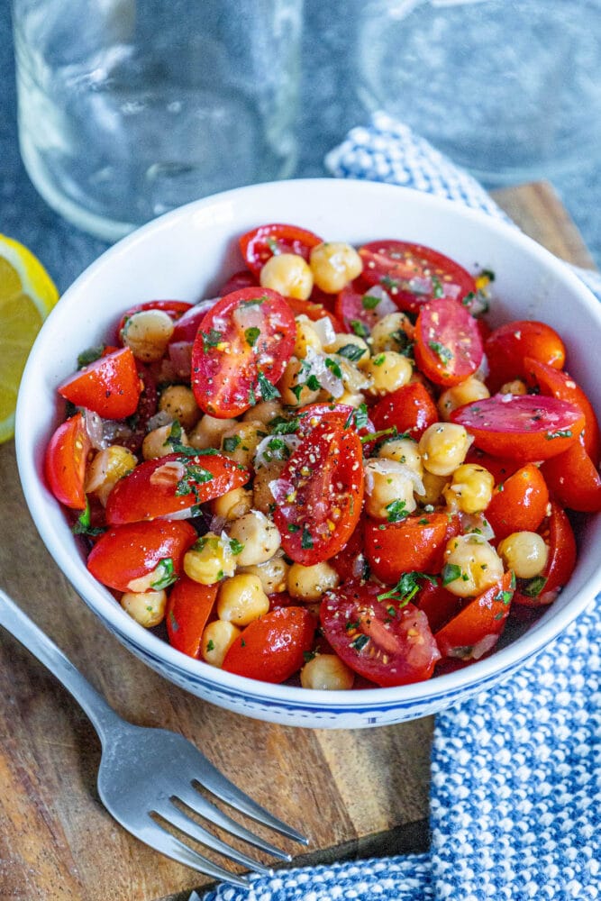 picture of tomatoes, chickpeas, shallots and herbs mixed in a bowl 