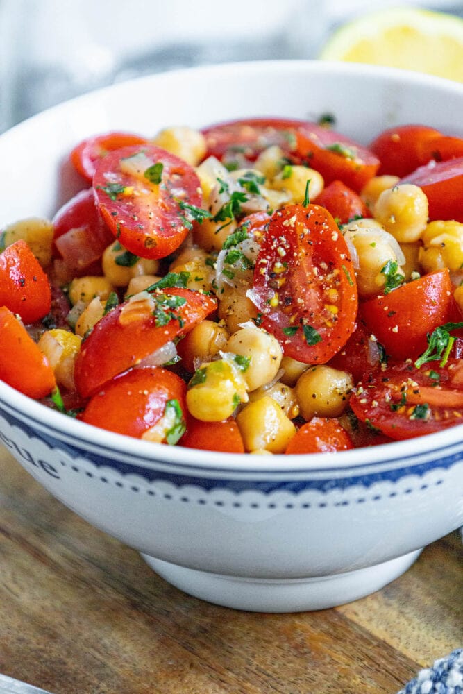 picture of tomatoes, chickpeas, shallots and herbs mixed in a bowl 