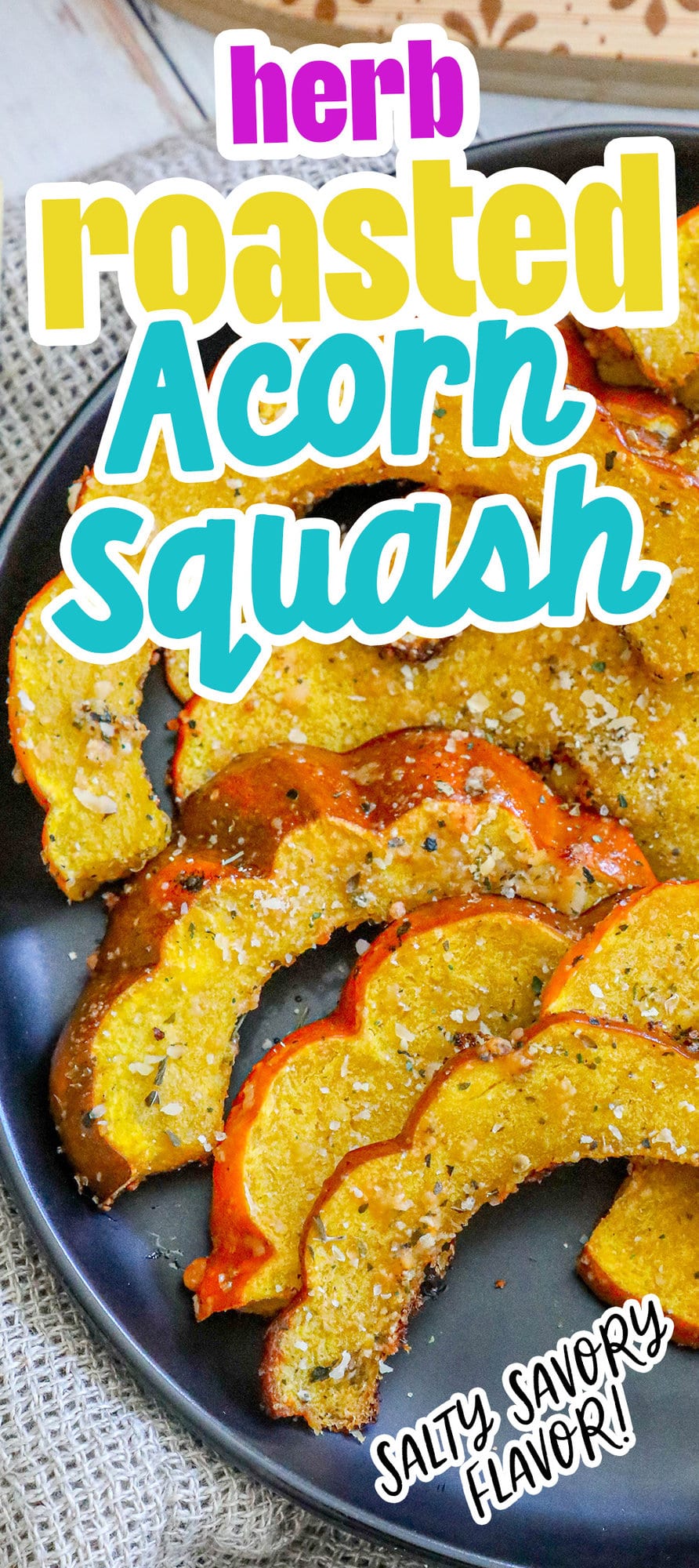 picture of roasted acorn squash slices seasoned with herbs and spices on a black plate