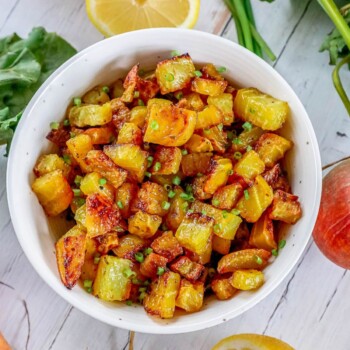 picture of golden roasted beets in a white bowl with chopped chives on top