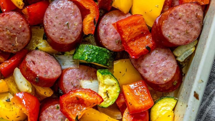 picture of turkey kielbasa, bell peppers, onions, and herb dressing baked on a baking sheet on a table