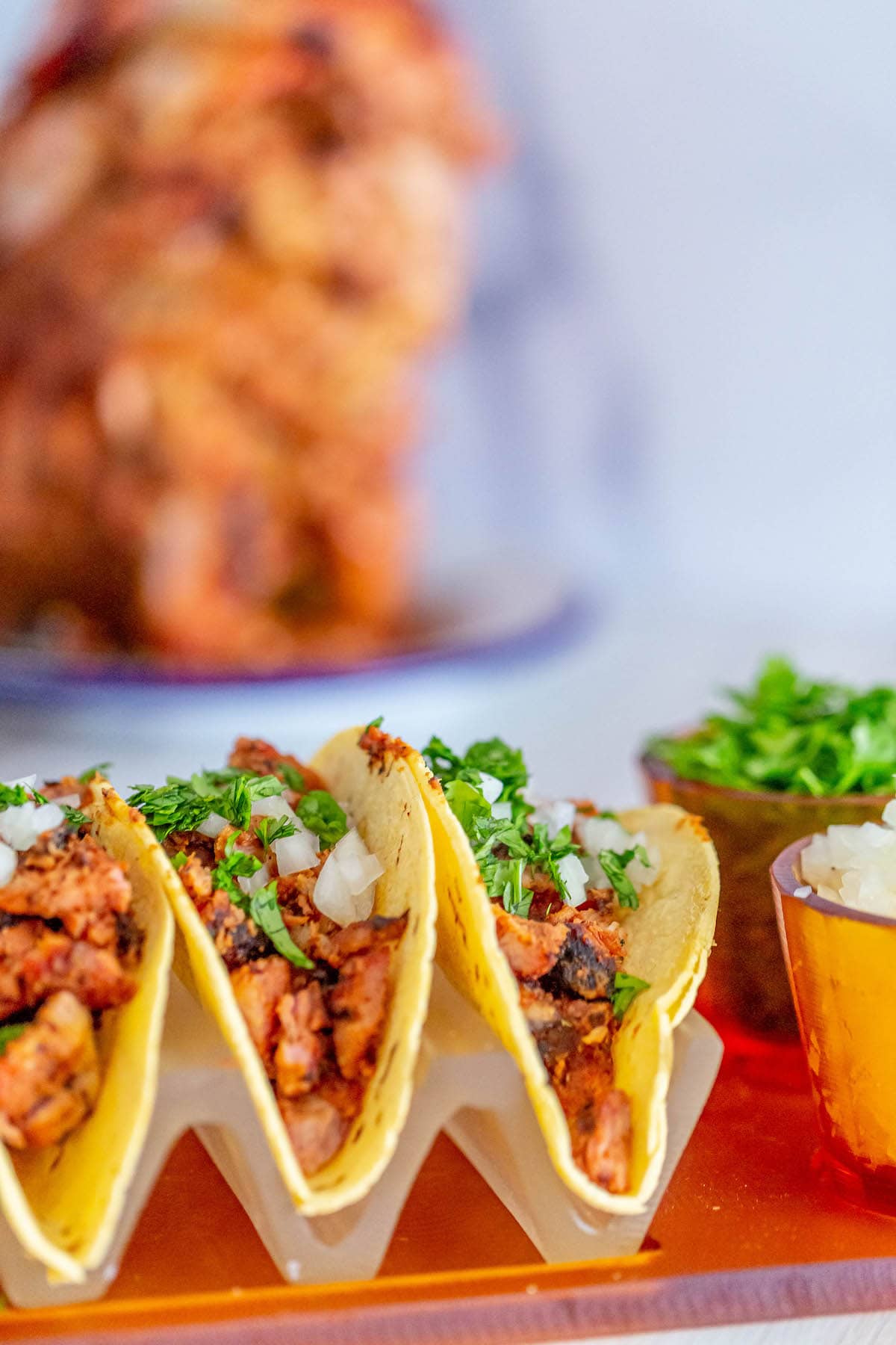 picture of chopped smoked al pastor in a taco topped with chopped cilantro and white onion