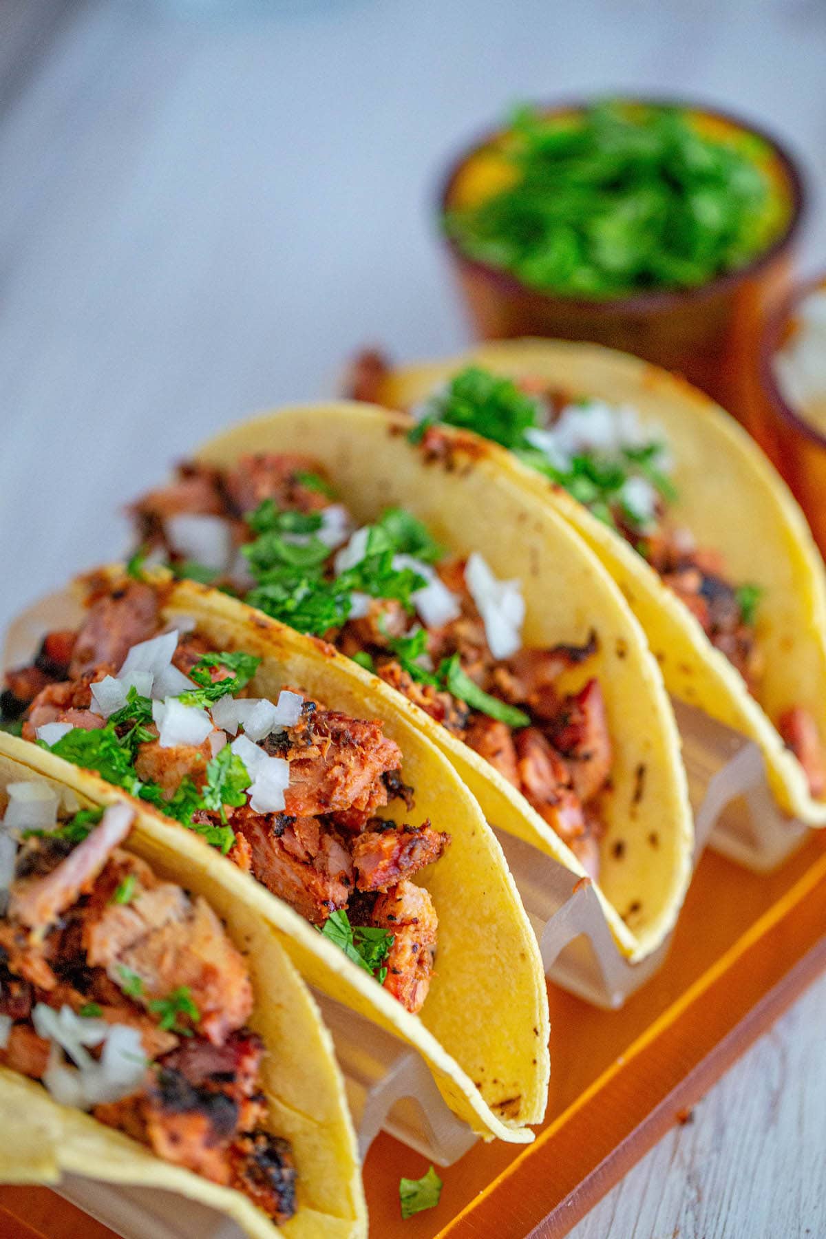 picture of chopped smoked al pastor in a taco topped with chopped cilantro and white onion