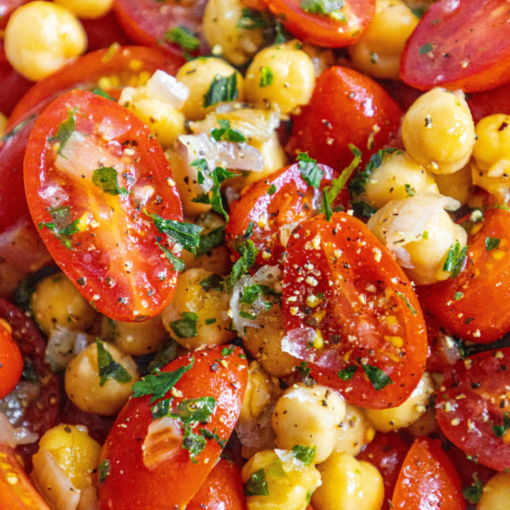 picture of tomatoes, chickpeas, shallots and herbs mixed in a bowl