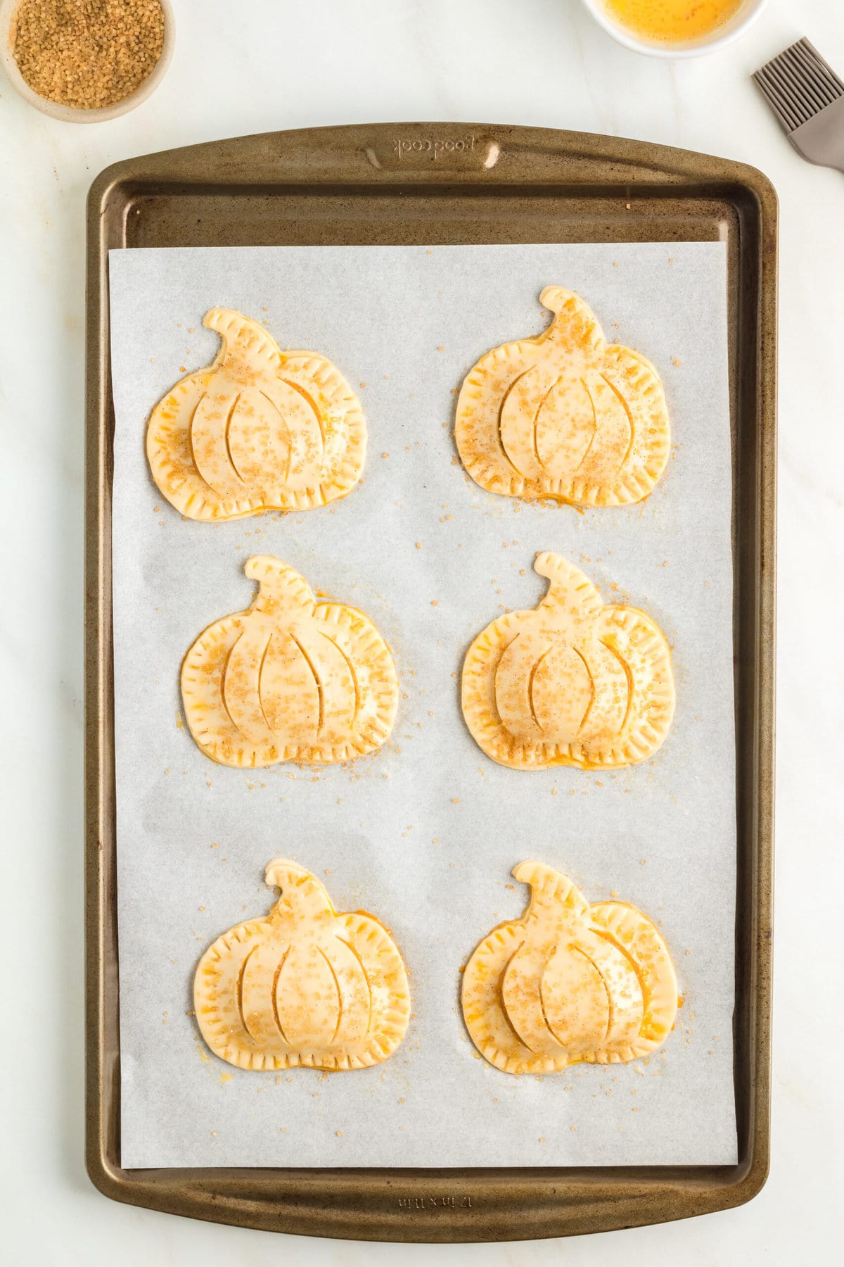 picture of raw hand pie formed on a baking sheet lined with parchment paper