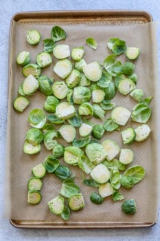 picture of brussels sprouts chopped in half on a baking sheet lined with parchment paper