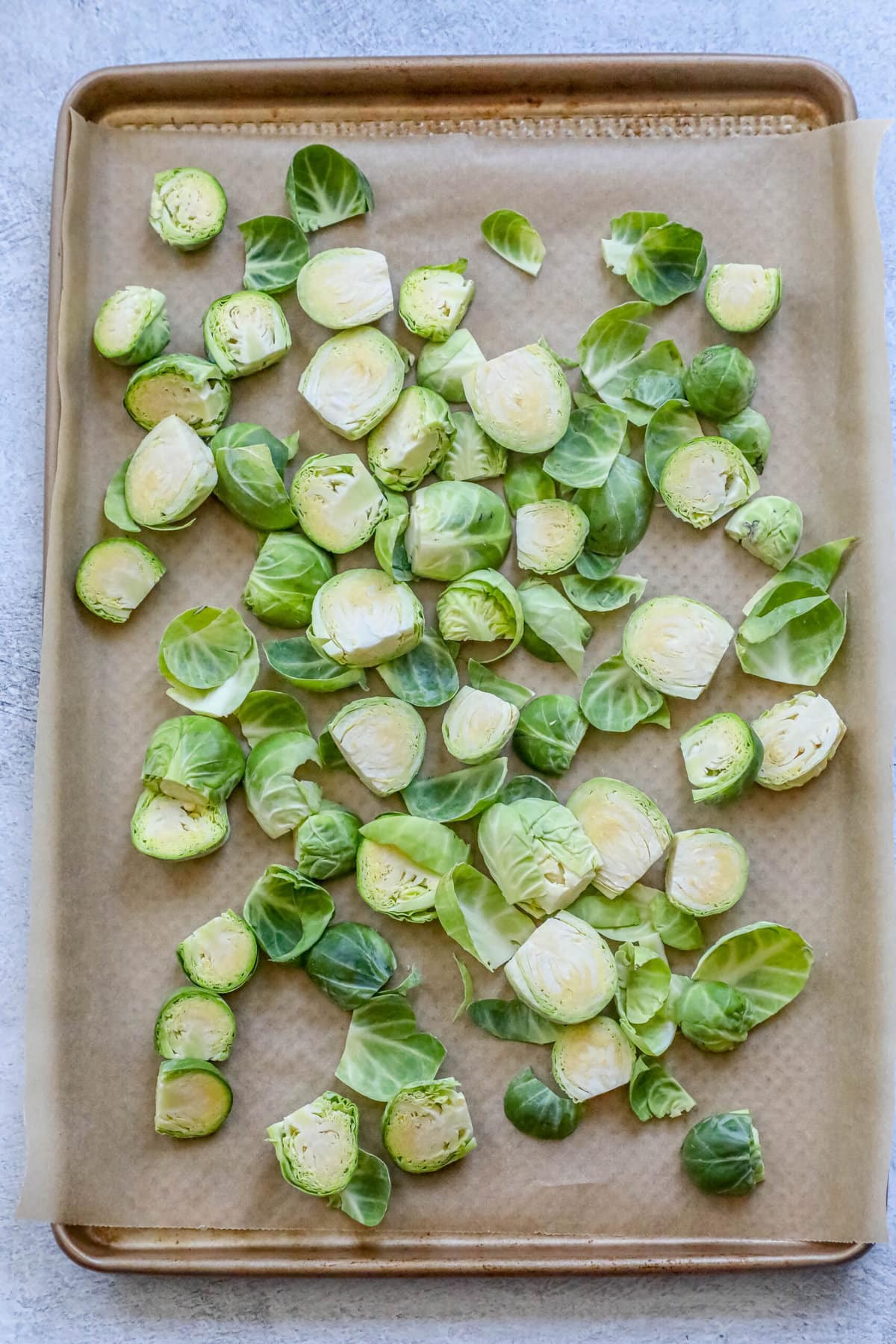 picture of brussels sprouts chopped in half on a baking sheet lined with parchment paper