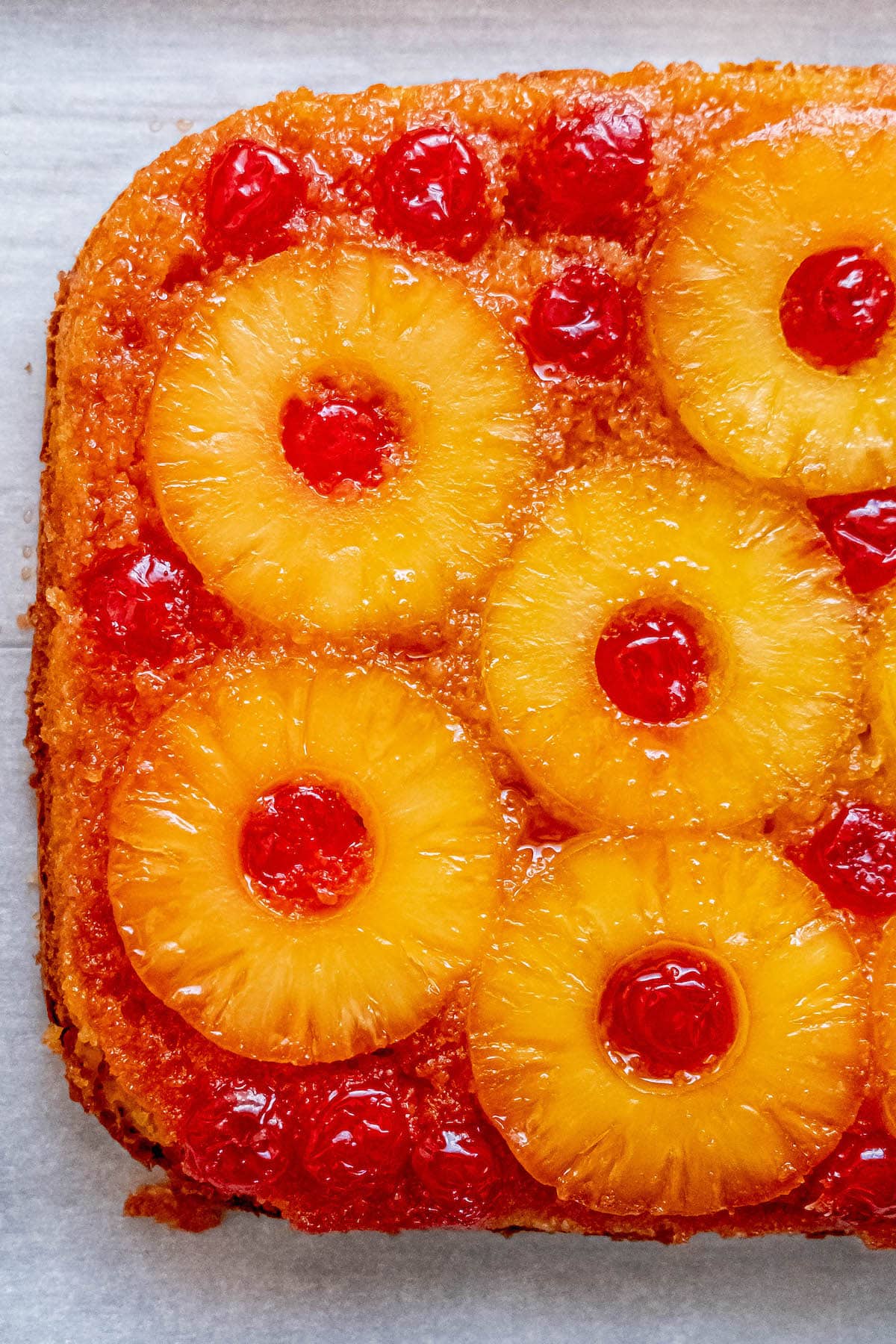 picture of pineapple upside down cake with a pineapples and maraschino cherries baked onto the top