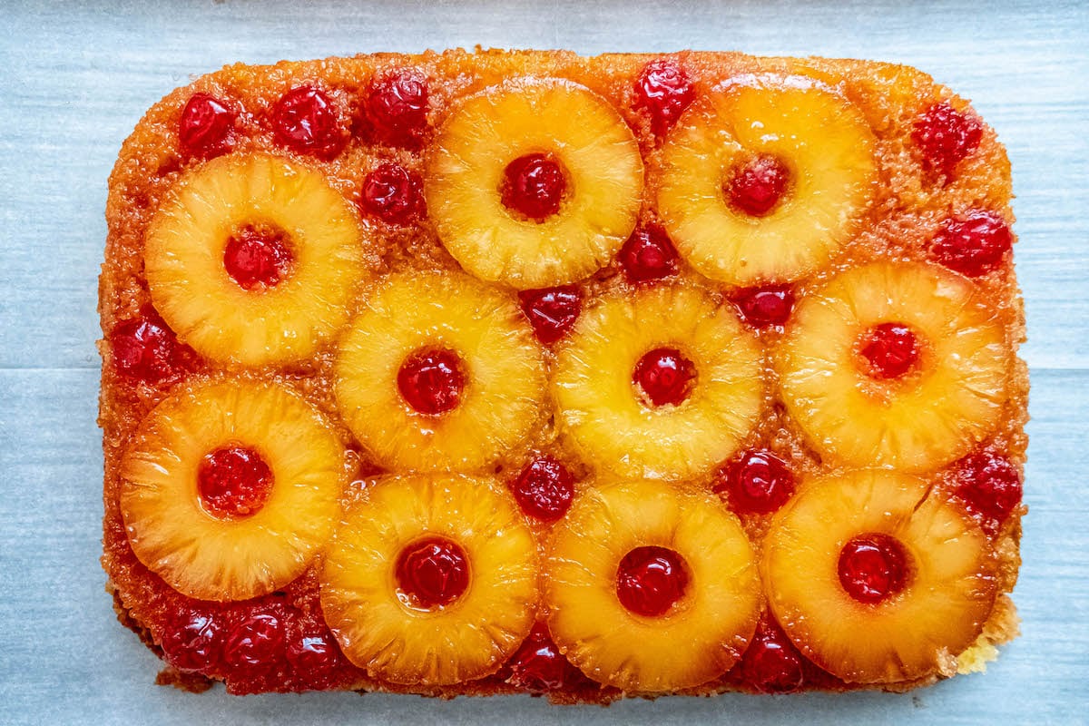 picture of pineapple upside down cake with a pineapples and maraschino cherries baked onto the top