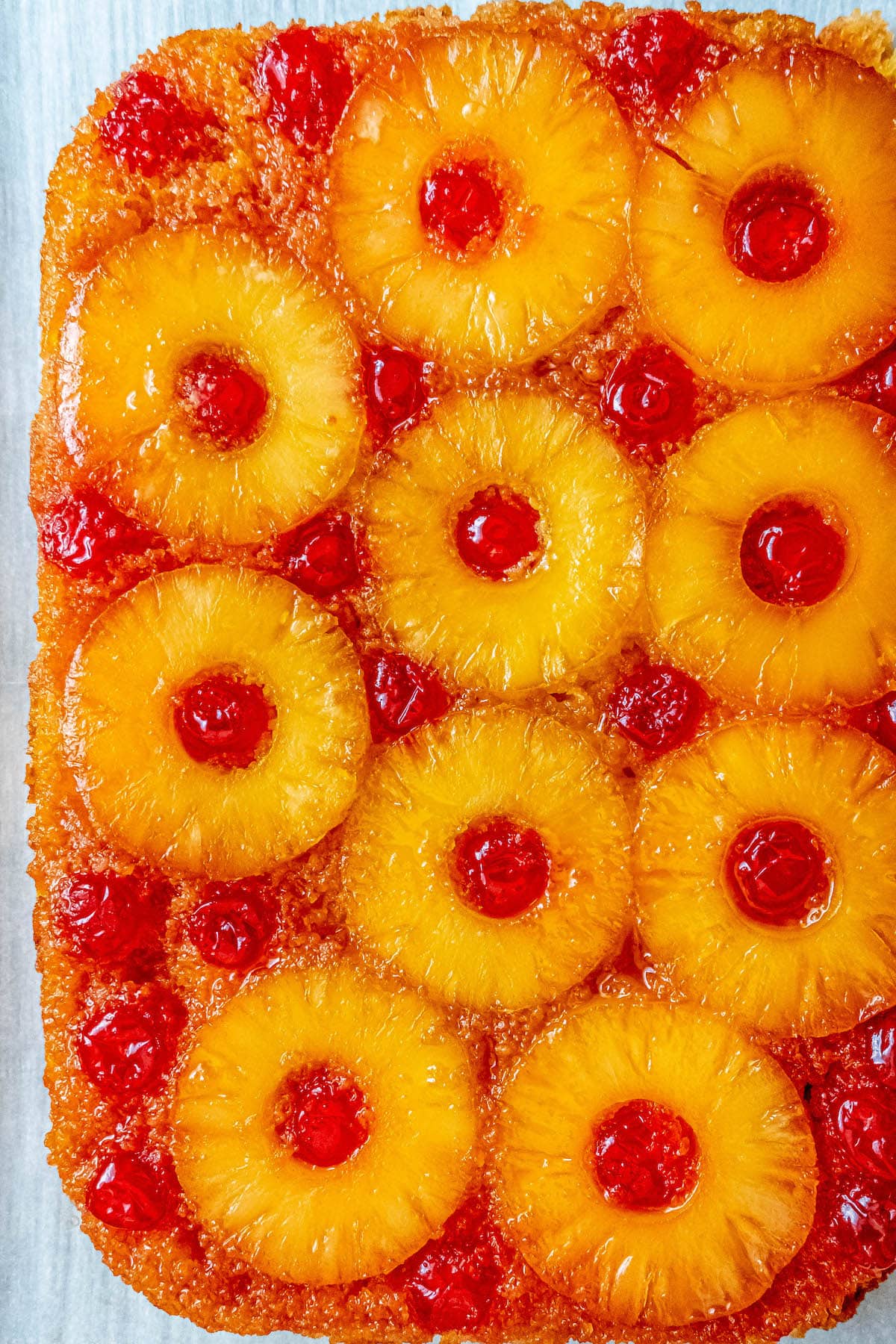 picture of pineapple upside down cake with a pineapples and maraschino cherries baked onto the top