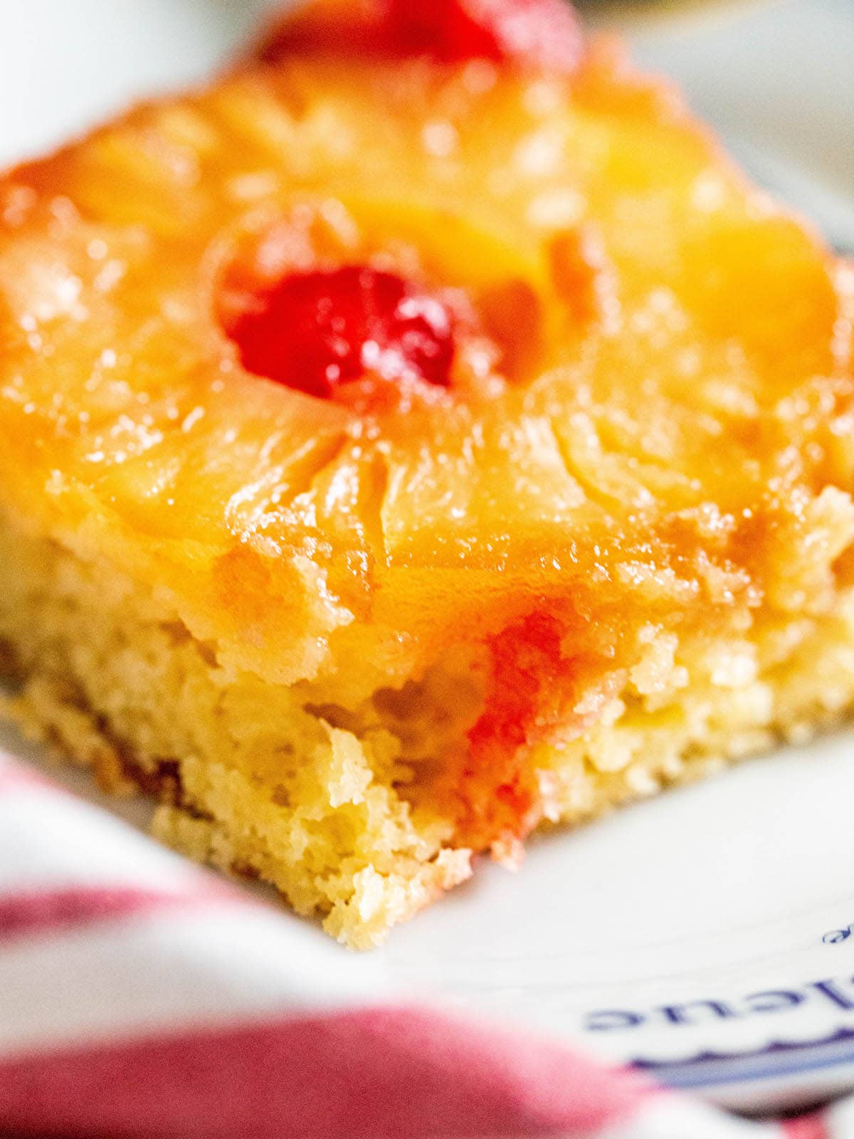 picture of a slice of pineapple upside down cake with a pineapples and maraschino cherries baked onto the top