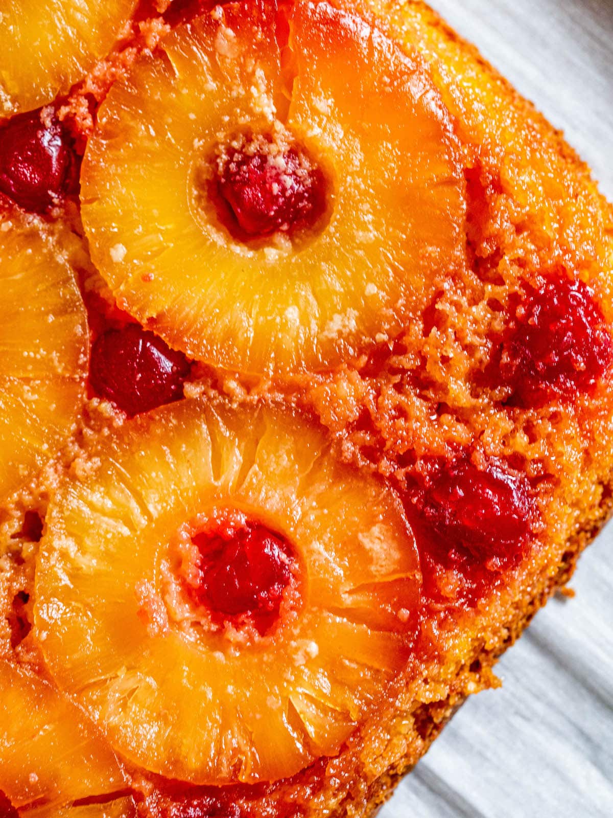 picture of pineapple upside down cake with a pineapples and maraschino cherries baked onto the top