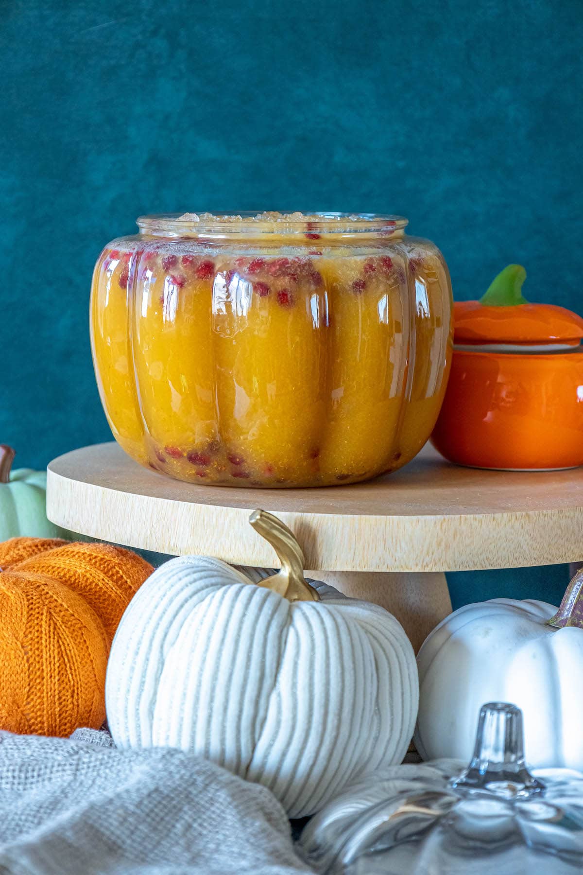 A jar of pumpkin pie punch sitting on top of a wooden stand.