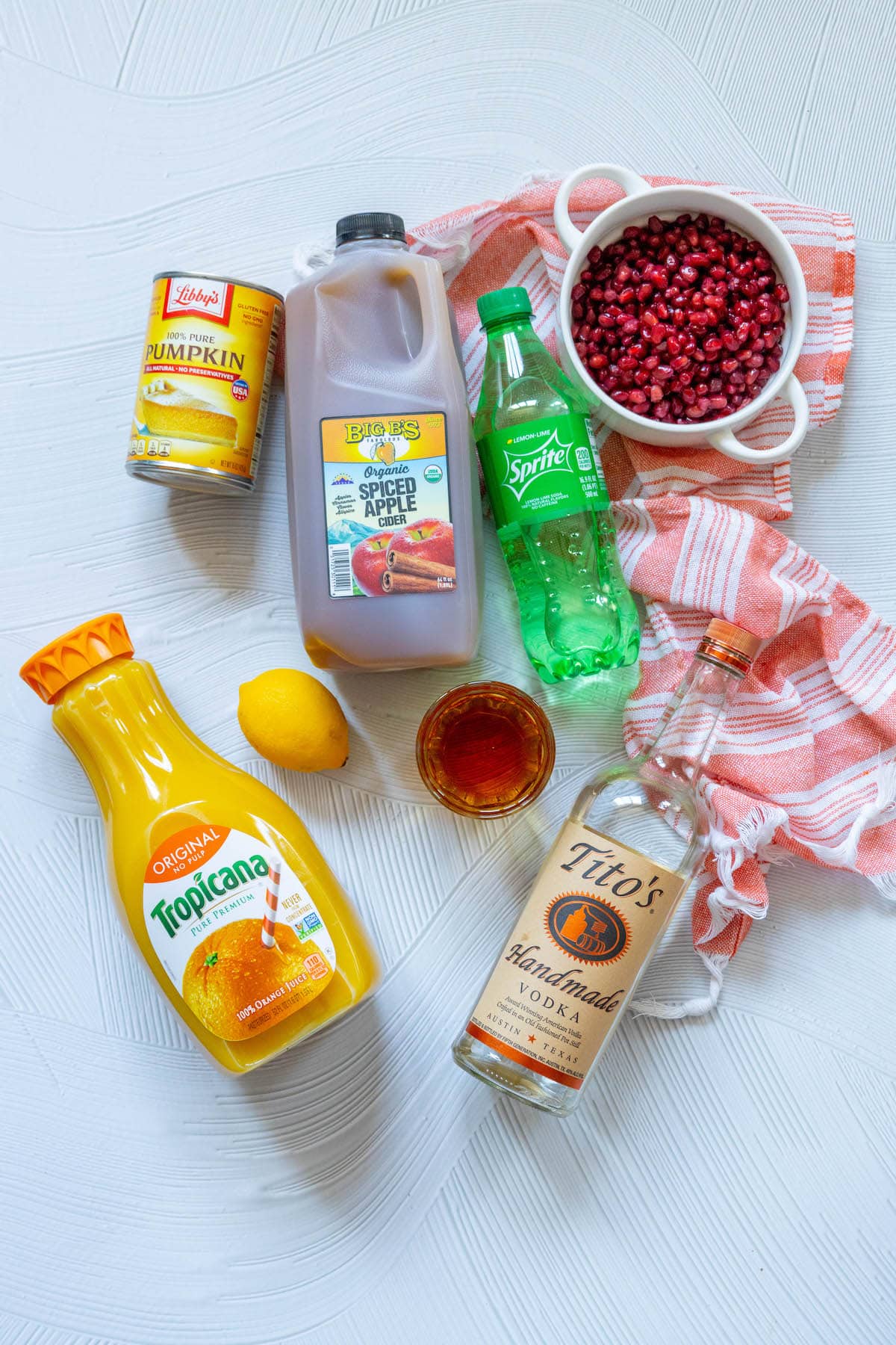 picture of brandy, vodka, sprite, pomegranate, pumpkin, apple cider on a table