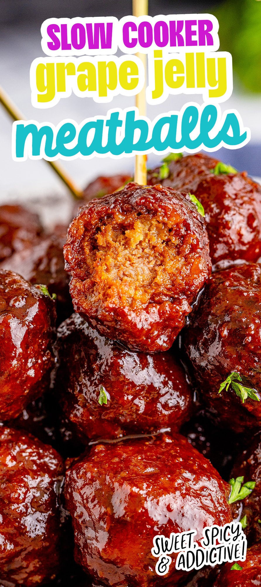 picture of a meatball with a toothpick in it and a bite taken out of it on top of a pile of grape jelly meatballs stacked on a plate with pieces of parsley chopped on top