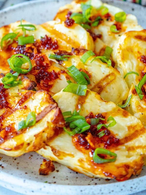 picture of grilled halloumi with cheese and spicy garlic honey on a plate with scallions
