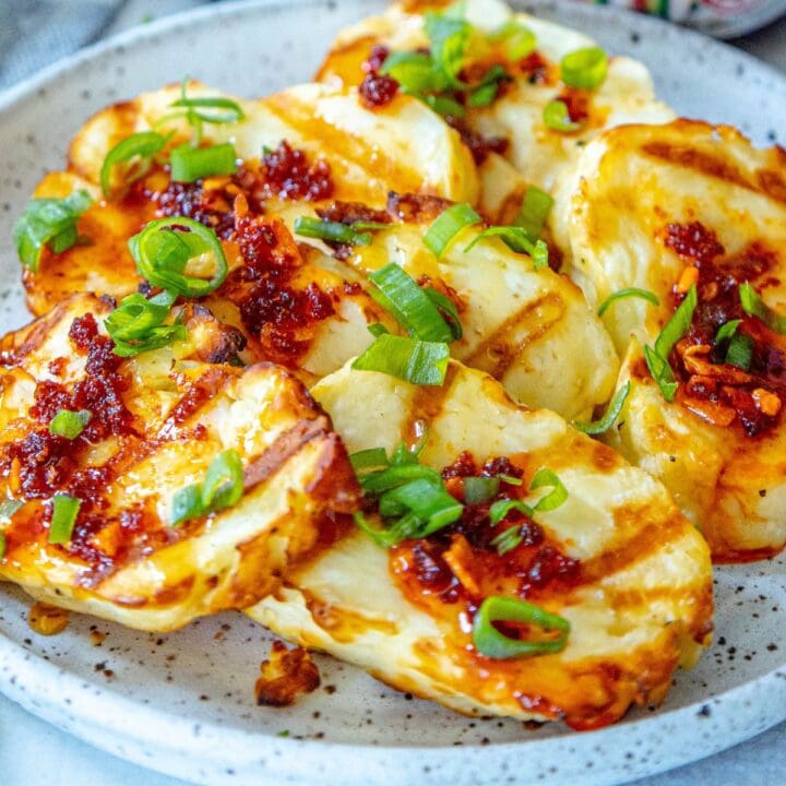picture of grilled halloumi with cheese and spicy garlic honey on a plate with scallions