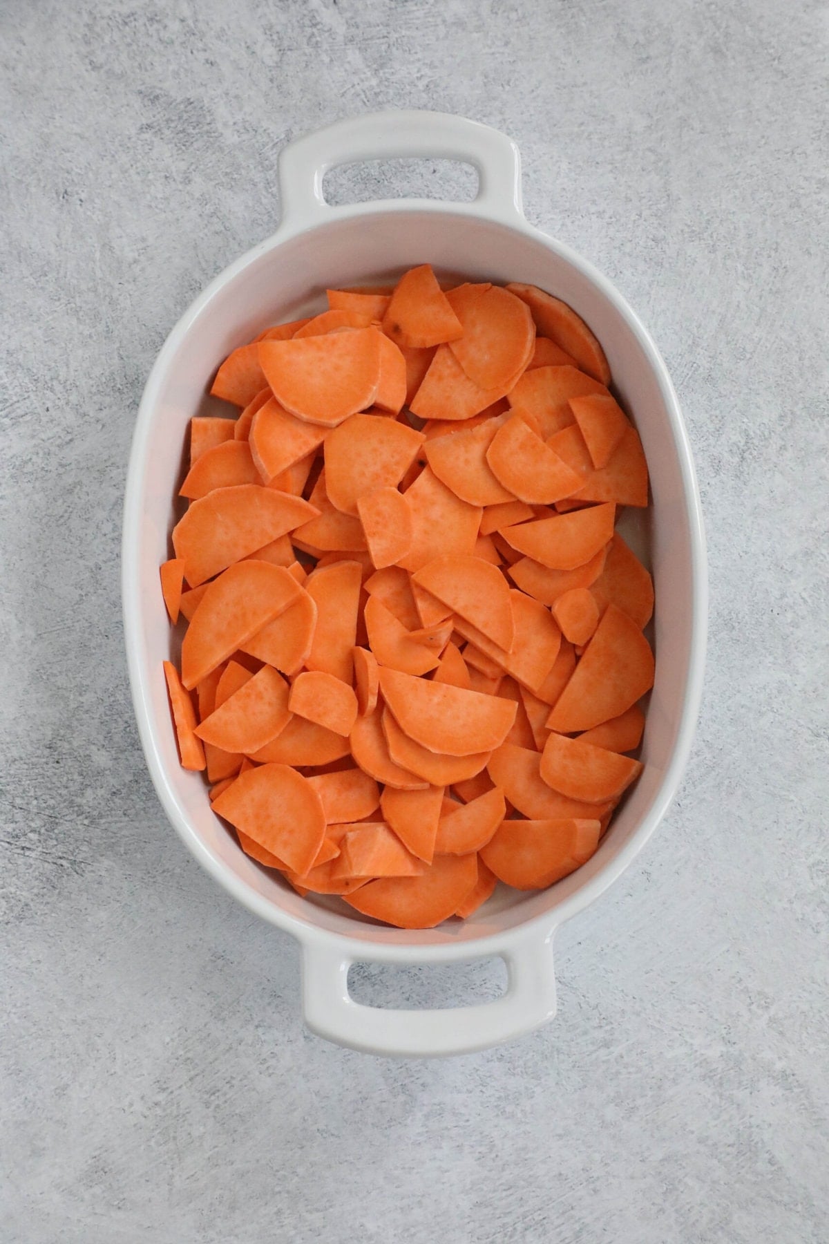 picture of sliced sweet potatoes in a baking dish