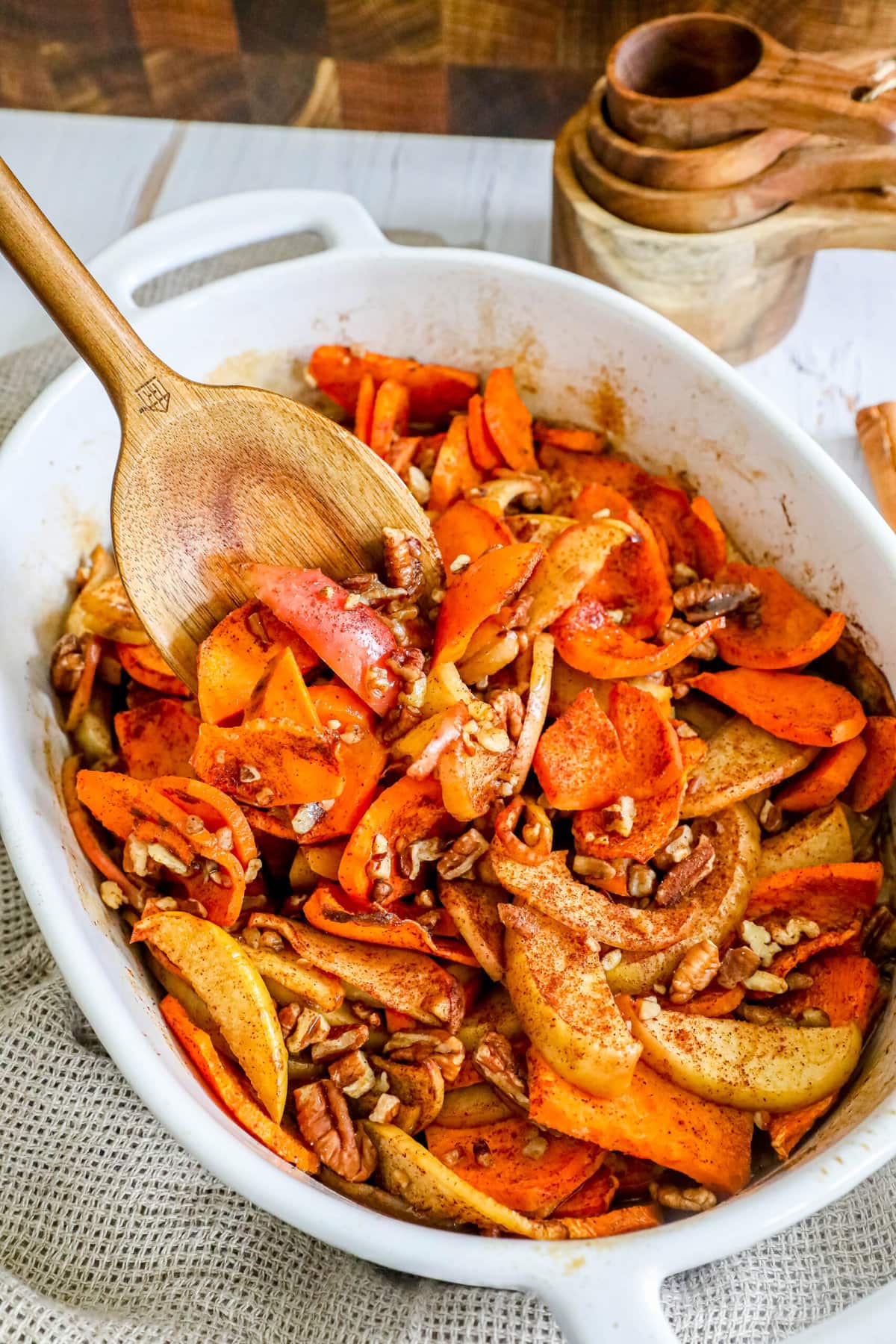 baked sweet potatoes and apples in a dish with cinnamon and nuts