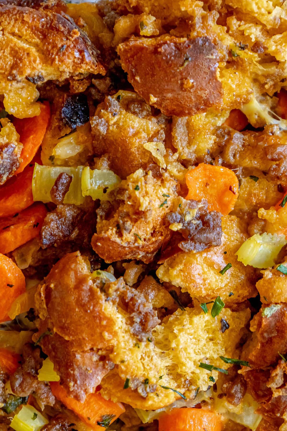 picture of cheeseburger stuffing in a glass tray on a table with carrots and herbs on top 