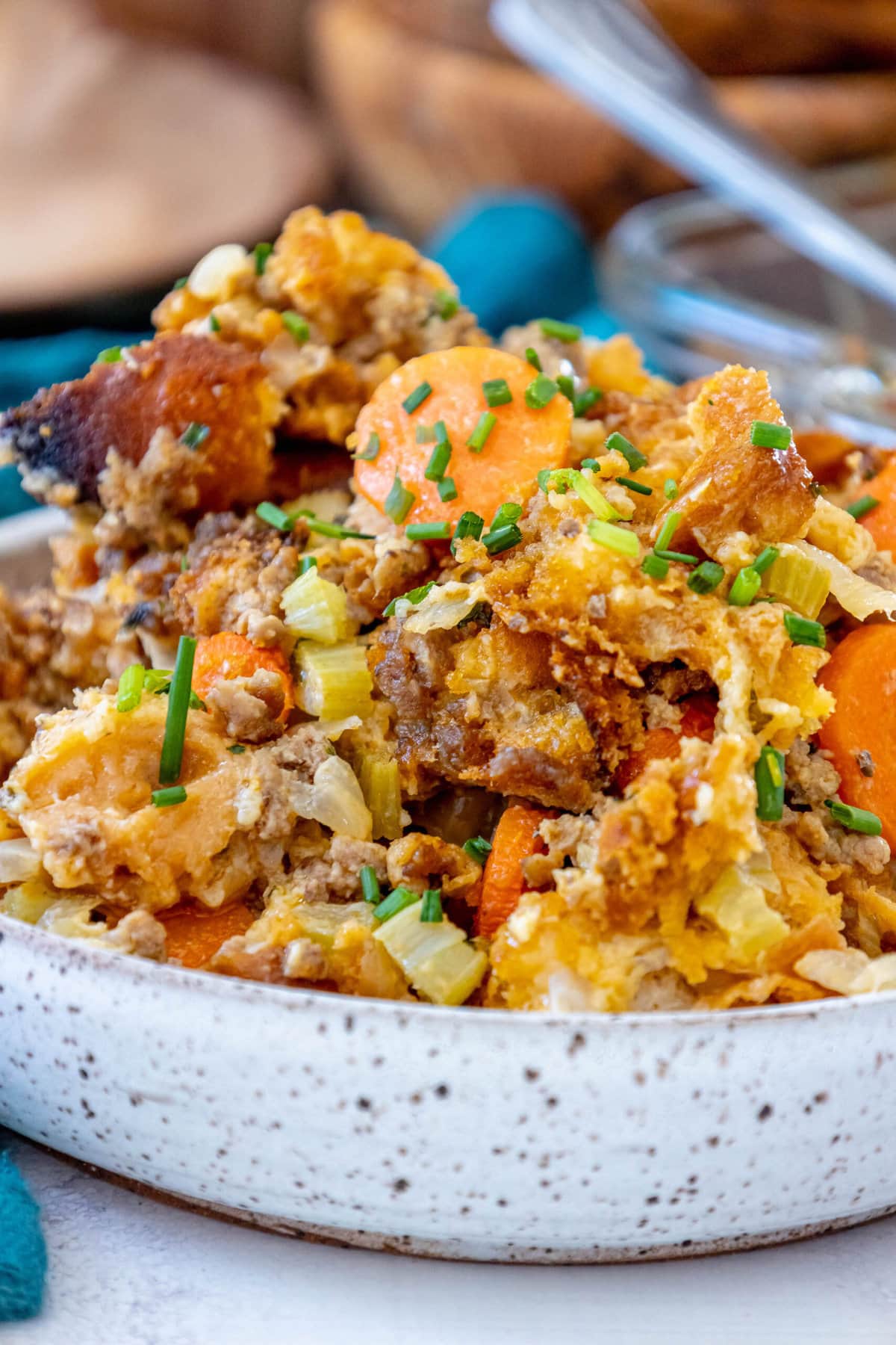 picture of cheeseburger stuffing in a glass tray on a table with carrots and herbs on top 