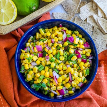 picture of corn salsa in a blue bowl with onions, jalapenos, cilantro