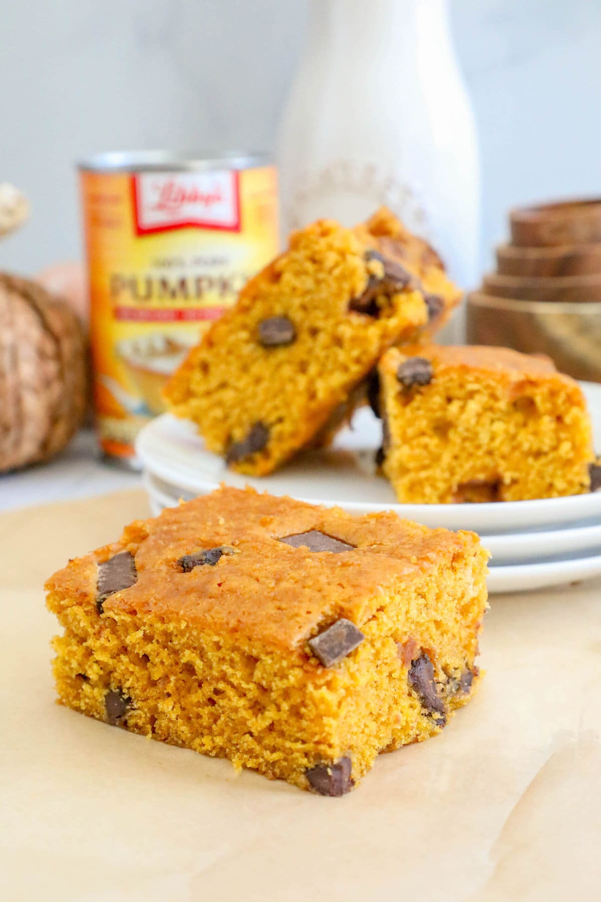 picture of baked pumpkin bars with chocolate chunks stacked on top of each other on a table