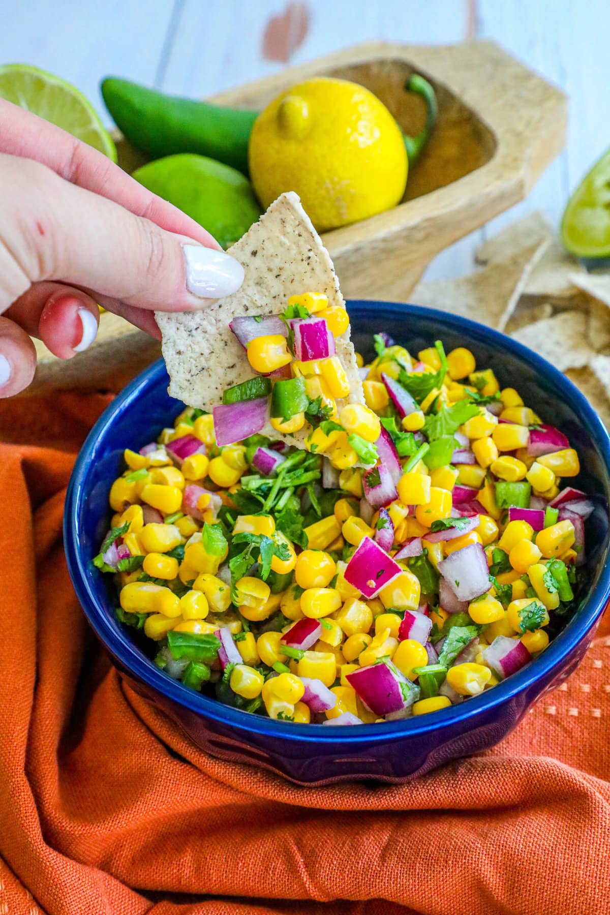 picture of corn salsa in a blue bowl with onions, jalapenos, cilantro