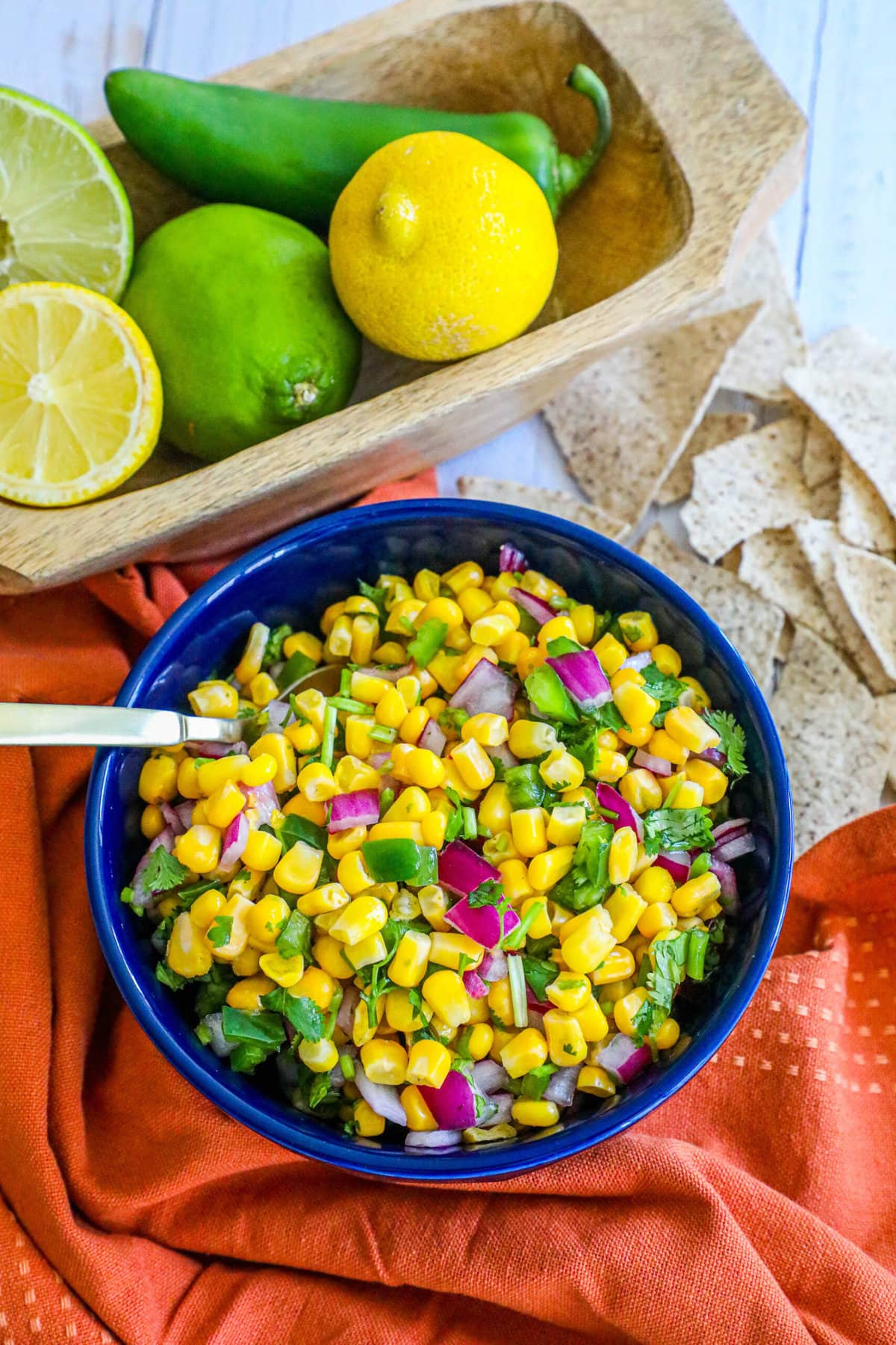 picture of corn salsa in a blue bowl with onions, jalapenos, cilantro