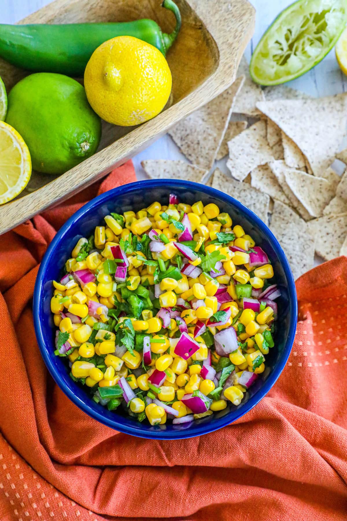 picture of corn salsa in a blue bowl with onions, jalapenos, cilantro